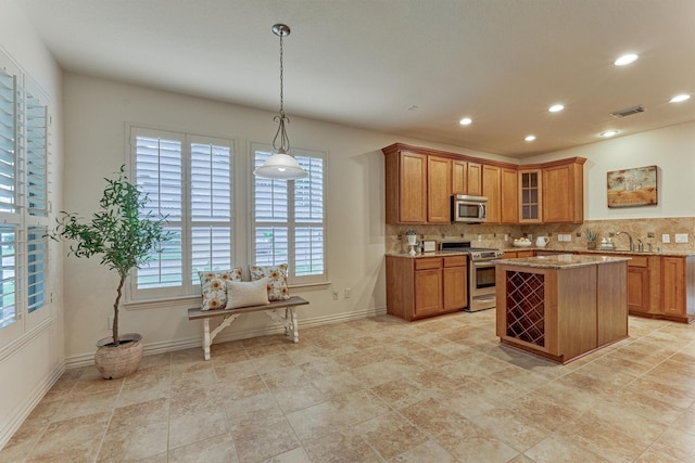71 Ginger Jar St, The Woodlands, TX 77382 - kitchen featuring appliances with stainless steel finishes, brown cabinetry, light stone counters, decorative backsplash, and recessed lighting
