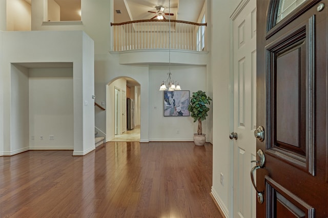 71 Ginger Jar St, The Woodlands, TX 77382 - foyer entrance with arched walkways, wood finished floors, a ceiling fan, a chandelier, and baseboards