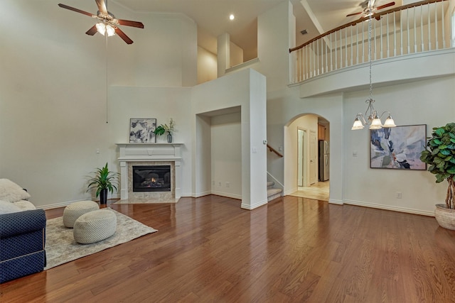 71 Ginger Jar St, The Woodlands, TX 77382 - living area with a ceiling fan, arched walkways, a towering ceiling, a premium fireplace, and stairs