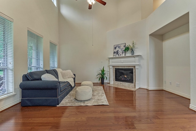 71 Ginger Jar St, The Woodlands, TX 77382 - living area featuring a towering ceiling, ceiling fan, wood finished floors, a high end fireplace, and baseboards