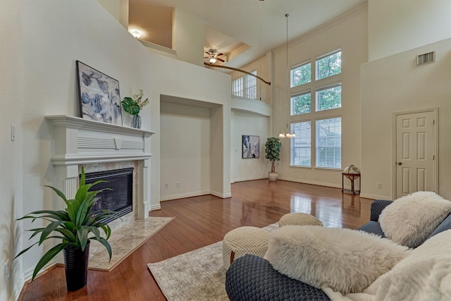 71 Ginger Jar St, The Woodlands, TX 77382 - living area with a ceiling fan, a high end fireplace, a towering ceiling, wood finished floors, and baseboards