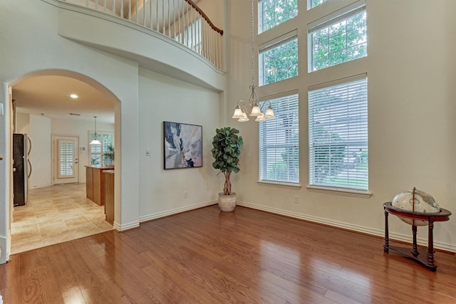 71 Ginger Jar St, The Woodlands, TX 77382 - entrance foyer with arched walkways, light wood-style floors, plenty of natural light, baseboards, and a towering ceiling