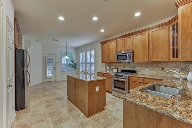 71 Ginger Jar St, The Woodlands, TX 77382 - kitchen with stainless steel appliances, a sink, a kitchen island, light stone countertops, and recessed lighting