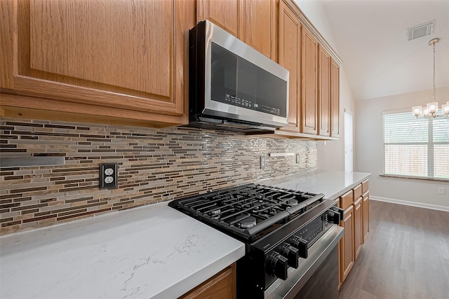 18314 Madisons Crossing Ln, Tomball, TX 77375 - kitchen with stainless steel microwave, black range with gas cooktop, tasteful backsplash, a chandelier, and vaulted ceiling