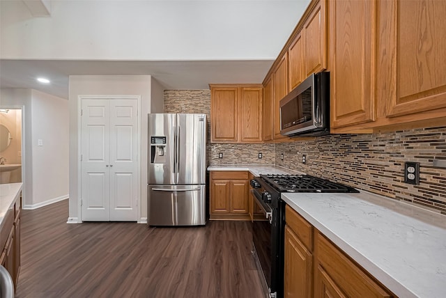 18314 Madisons Crossing Ln, Tomball, TX 77375 - kitchen featuring stainless steel appliances, dark wood-type flooring, decorative backsplash, and brown cabinetry