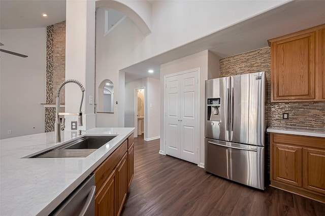 18314 Madisons Crossing Ln, Tomball, TX 77375 - kitchen featuring appliances with stainless steel finishes, a sink, tasteful backsplash, dark wood finished floors, and brown cabinets