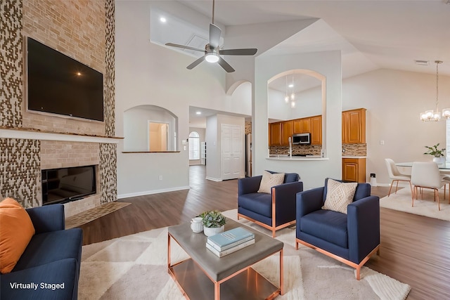 18314 Madisons Crossing Ln, Tomball, TX 77375 - living area with wood finished floors, a ceiling fan, arched walkways, high vaulted ceiling, and a chandelier
