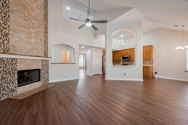 18314 Madisons Crossing Ln, Tomball, TX 77375 - unfurnished living room with high vaulted ceiling, a ceiling fan, dark wood-style floors, baseboards, and a chandelier