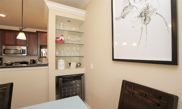 indoor dry bar with stainless steel microwave, beverage cooler, ornamental molding, backsplash, and recessed lighting