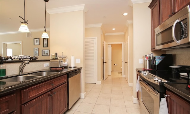 kitchen featuring appliances with stainless steel finishes, ornamental molding, a sink, light tile patterned flooring, and hanging light fixtures