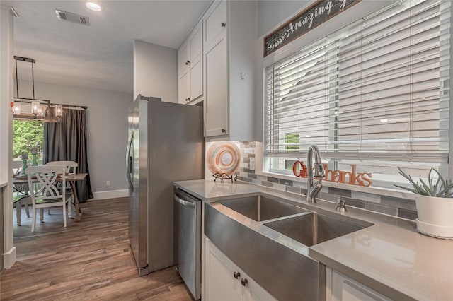 16 Wildwood Lake Dr, Huntsville, TX 77340 - kitchen featuring appliances with stainless steel finishes, a sink, white cabinets, tasteful backsplash, and plenty of natural light