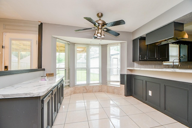 4719 Theall Rd, Houston, TX 77066 - kitchen featuring a sink, light countertops, ceiling fan, light tile patterned flooring, and decorative backsplash