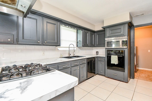 4719 Theall Rd, Houston, TX 77066 - kitchen with black appliances, a sink, tasteful backsplash, light tile patterned floors, and light stone counters