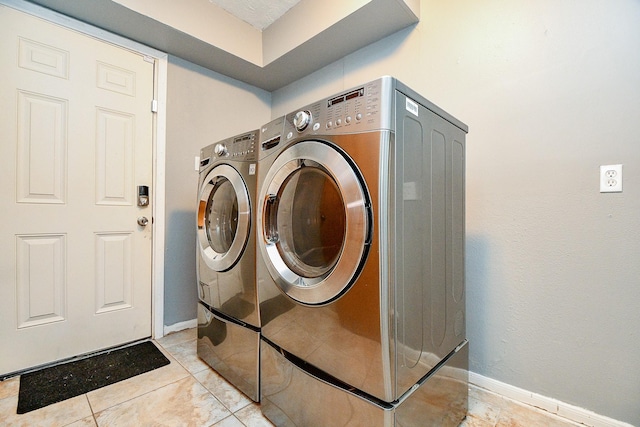 4719 Theall Rd, Houston, TX 77066 - laundry area featuring washer and dryer, baseboards, and light tile patterned flooring