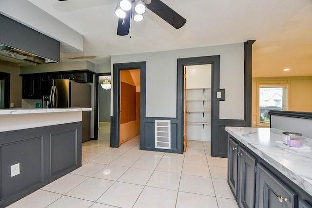 4719 Theall Rd, Houston, TX 77066 - kitchen with a ceiling fan, light tile patterned flooring, fridge with ice dispenser, light stone counters, and dark cabinetry
