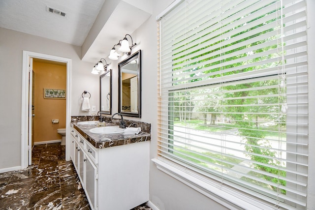 4719 Theall Rd, Houston, TX 77066 - bathroom featuring marble tiled floors, baseboards, plenty of natural light, and toilet