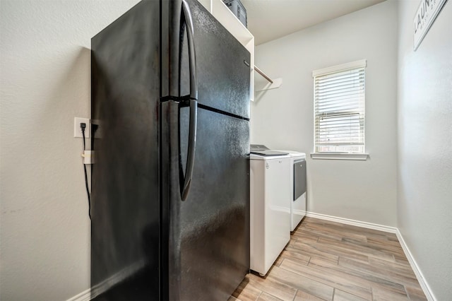 211 Clementine Ct, Montgomery, TX 77316 - washroom featuring washer and clothes dryer, light wood finished floors, and baseboards