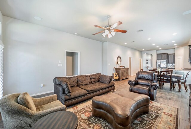 211 Clementine Ct, Montgomery, TX 77316 - living area featuring ceiling fan, arched walkways, light wood-style flooring, recessed lighting, and baseboards