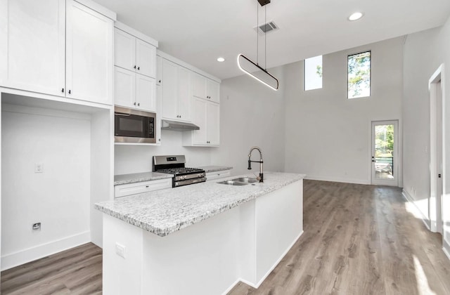 5609 Savyon Dr, Houston, TX 77091 - kitchen with a sink, appliances with stainless steel finishes, white cabinets, light wood-style floors, and baseboards