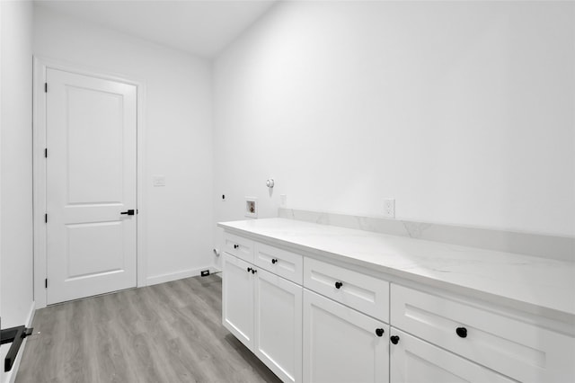 111 Capetown Way, Conroe, TX 77356 - washroom featuring cabinet space, hookup for an electric dryer, light wood-style floors, washer hookup, and baseboards