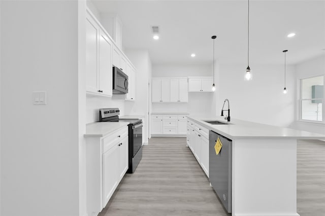 111 Capetown Way, Conroe, TX 77356 - kitchen with stainless steel appliances, a sink, light countertops, light wood-style floors, and recessed lighting