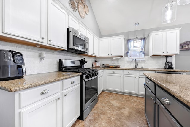 2201 Piney Wood Dr, Deer Park, TX 77536 - kitchen featuring appliances with stainless steel finishes, a sink, white cabinetry, backsplash, and vaulted ceiling