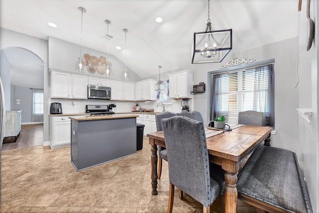 2201 Piney Wood Dr, Deer Park, TX 77536 - dining area featuring vaulted ceiling, arched walkways, and a chandelier