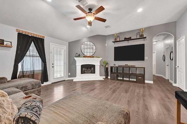 2201 Piney Wood Dr, Deer Park, TX 77536 - living area with a ceiling fan, arched walkways, wood finished floors, baseboards, and a fireplace with raised hearth