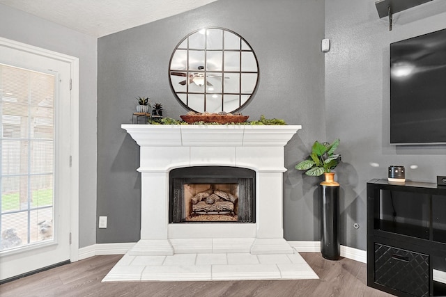 2201 Piney Wood Dr, Deer Park, TX 77536 - detailed view of wood finished floors, a fireplace with raised hearth, baseboards, and a textured wall