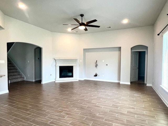 4923 Lacebark Pine Trl, Rosenberg, TX 77471 - unfurnished living room with arched walkways, a ceiling fan, wood finished floors, and recessed lighting