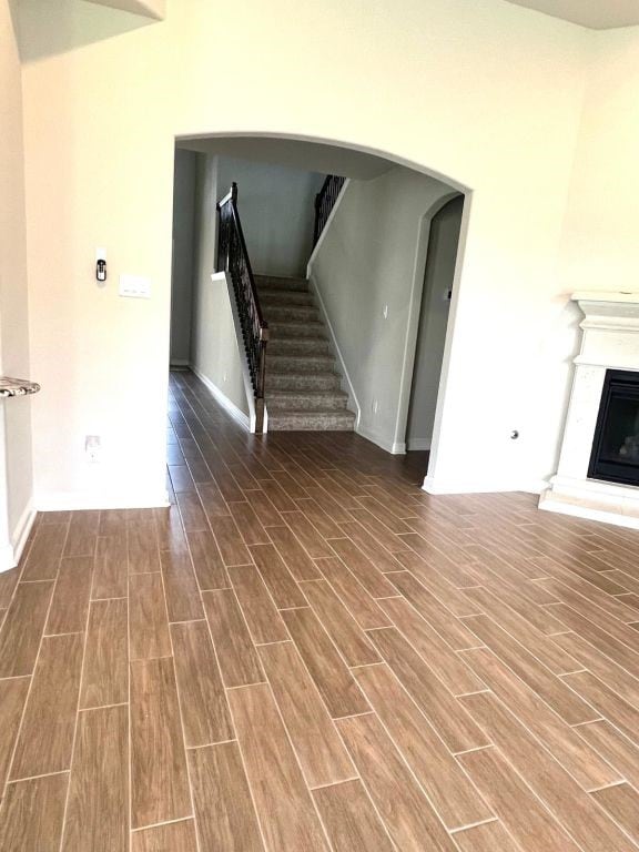 4923 Lacebark Pine Trl, Rosenberg, TX 77471 - unfurnished living room with wood finished floors, stairway, a glass covered fireplace, and baseboards