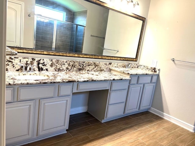 4923 Lacebark Pine Trl, Rosenberg, TX 77471 - bathroom featuring a stall shower, baseboards, double vanity, and wood tiled floors