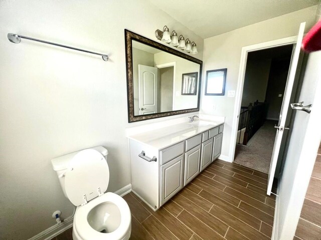 4923 Lacebark Pine Trl, Rosenberg, TX 77471 - bathroom featuring baseboards, wood tiled floors, vanity, and toilet