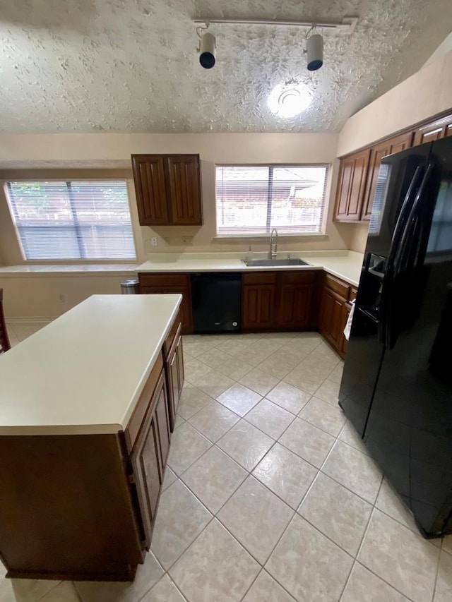 1903 Barons Gln, Sugar Land, TX 77478 - kitchen with black appliances, a sink, light countertops, light tile patterned floors, and a textured ceiling