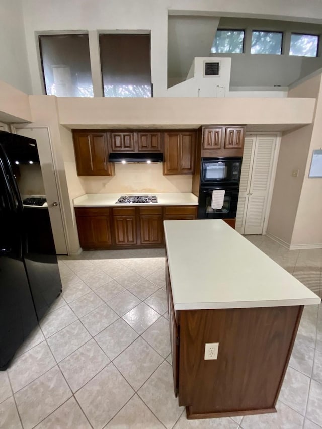 1903 Barons Gln, Sugar Land, TX 77478 - kitchen featuring black appliances, light tile patterned floors, light countertops, and a towering ceiling
