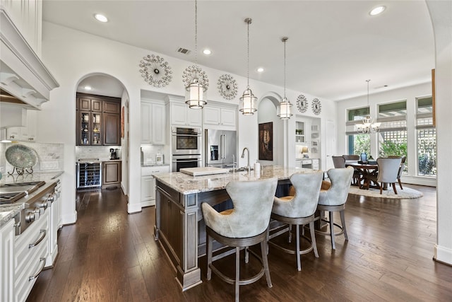 5518 Fleming Rock Ln, Fulshear, TX 77441 - kitchen featuring appliances with stainless steel finishes, a center island with sink, light stone countertops, white cabinets, and recessed lighting