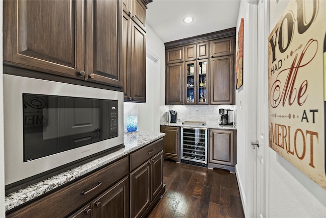5518 Fleming Rock Ln, Fulshear, TX 77441 - indoor bar featuring wine cooler, stainless steel microwave, dark wood finished floors, recessed lighting, and tasteful backsplash