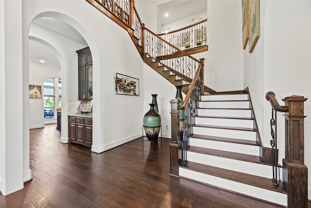5518 Fleming Rock Ln, Fulshear, TX 77441 - stairway with hardwood / wood-style floors, baseboards, recessed lighting, arched walkways, and a towering ceiling