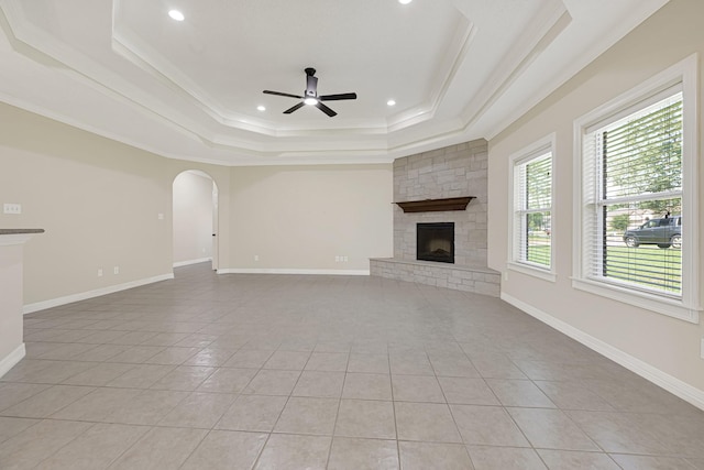 1207 S Diamondhead Blvd, Crosby, TX 77532 - unfurnished living room with a tray ceiling, light tile patterned floors, a ceiling fan, a fireplace, and arched walkways