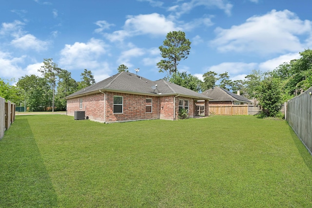 1207 S Diamondhead Blvd, Crosby, TX 77532 - rear view of house featuring central air condition unit, brick siding, and roof with shingles
