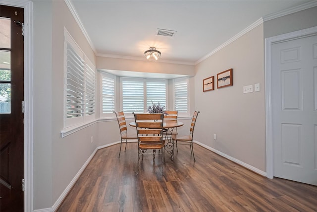 dining room featuring wood finished floors, baseboards, and ornamental molding