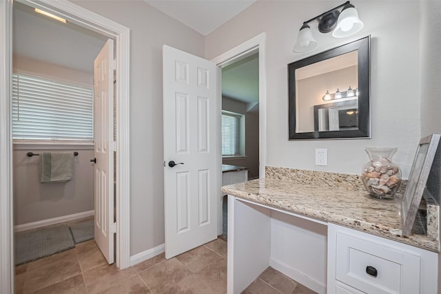 bathroom with vanity, baseboards, and tile patterned floors