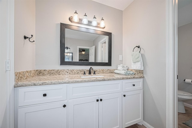bathroom with vanity, toilet, and baseboards