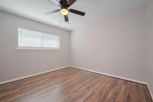 empty room featuring wood finished floors, baseboards, and ceiling fan