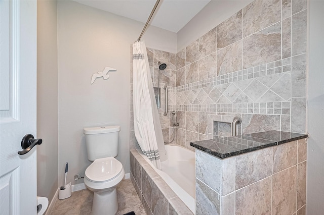 bathroom with toilet, tiled shower / bath, and baseboards