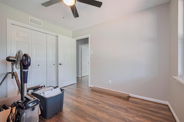bedroom with wood finished floors, baseboards, a closet, and ceiling fan