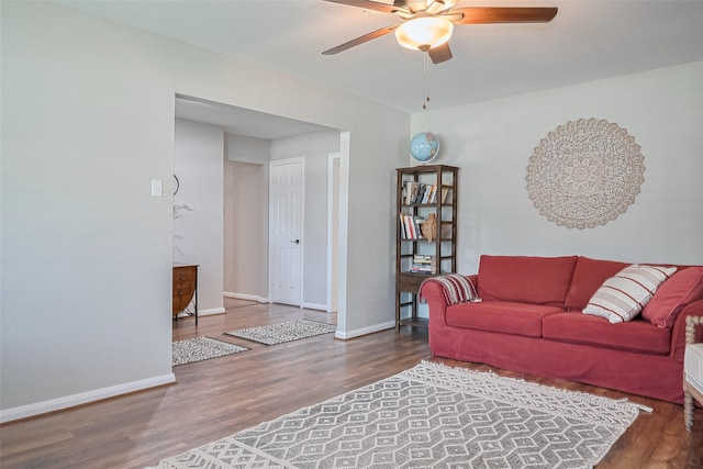 living room featuring ceiling fan, wood finished floors, and baseboards