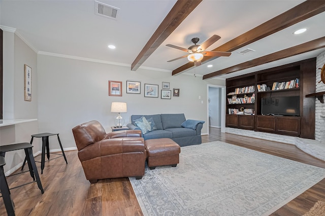 living area featuring wood finished floors, a ceiling fan, beamed ceiling, baseboards, and crown molding