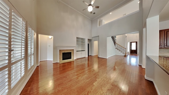 11111 Monte Rosa Ct, Richmond, TX 77406 - unfurnished living room with a high ceiling, ceiling fan, wood finished floors, stairs, and built in features
