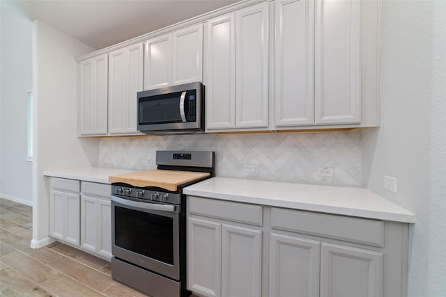 19806 Lone Paddock Cir, Tomball, TX 77377 - kitchen featuring stainless steel appliances, backsplash, light countertops, and light wood finished floors